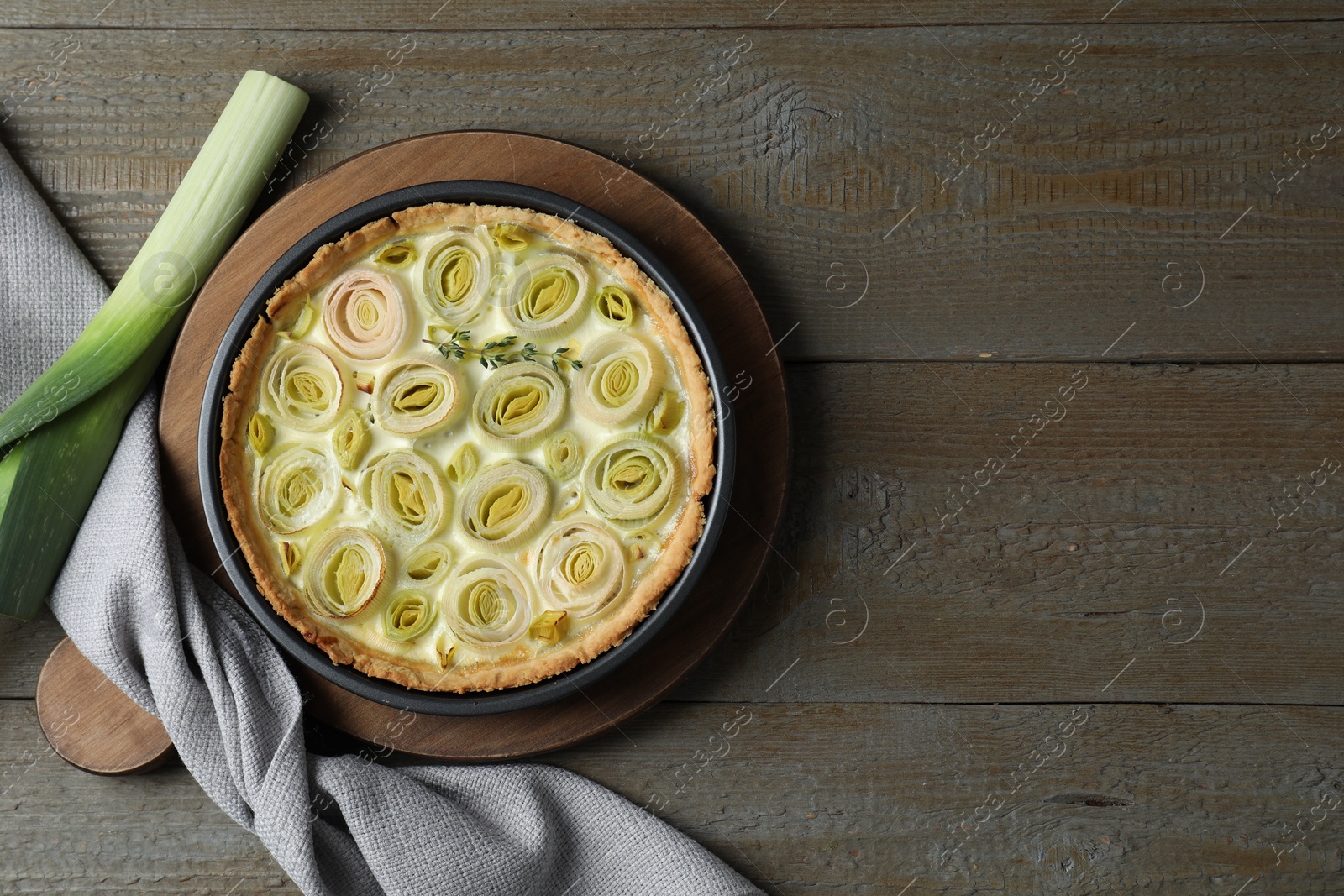 Photo of Tasty leek pie on wooden table, flat lay. Space for text