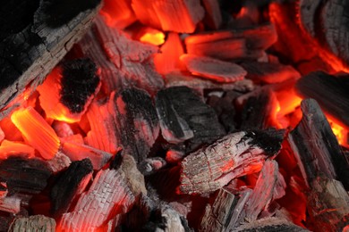 Photo of Pieces of hot smoldering coal as background, closeup