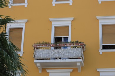 View of beautiful yellow building with balcony outdoors