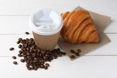 Photo of Coffee to go. Paper cup with tasty drink, croissant and beans on white wooden table