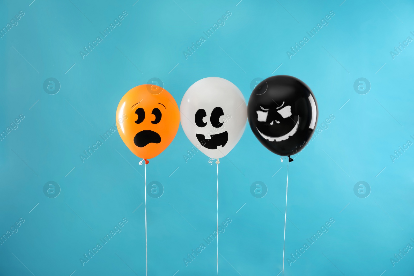 Photo of Spooky balloons for Halloween party on blue background