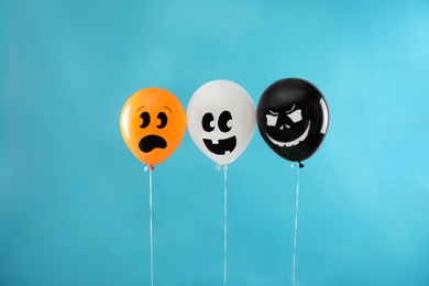 Photo of Spooky balloons for Halloween party on blue background