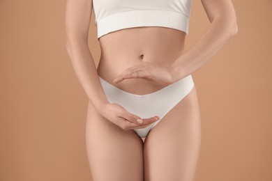 Photo of Gynecology. Woman in underwear on beige background, closeup