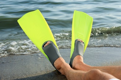 Photo of Man in flippers on sandy beach, closeup