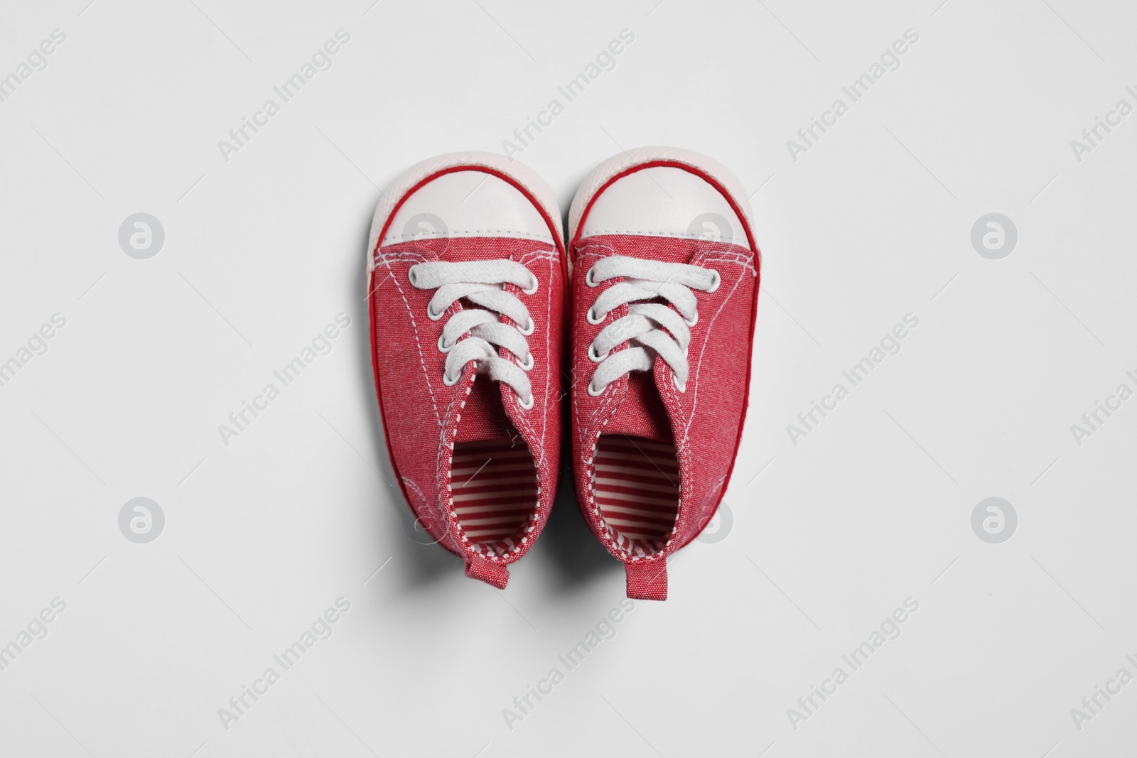 Photo of Cute baby shoes on white background, flat lay