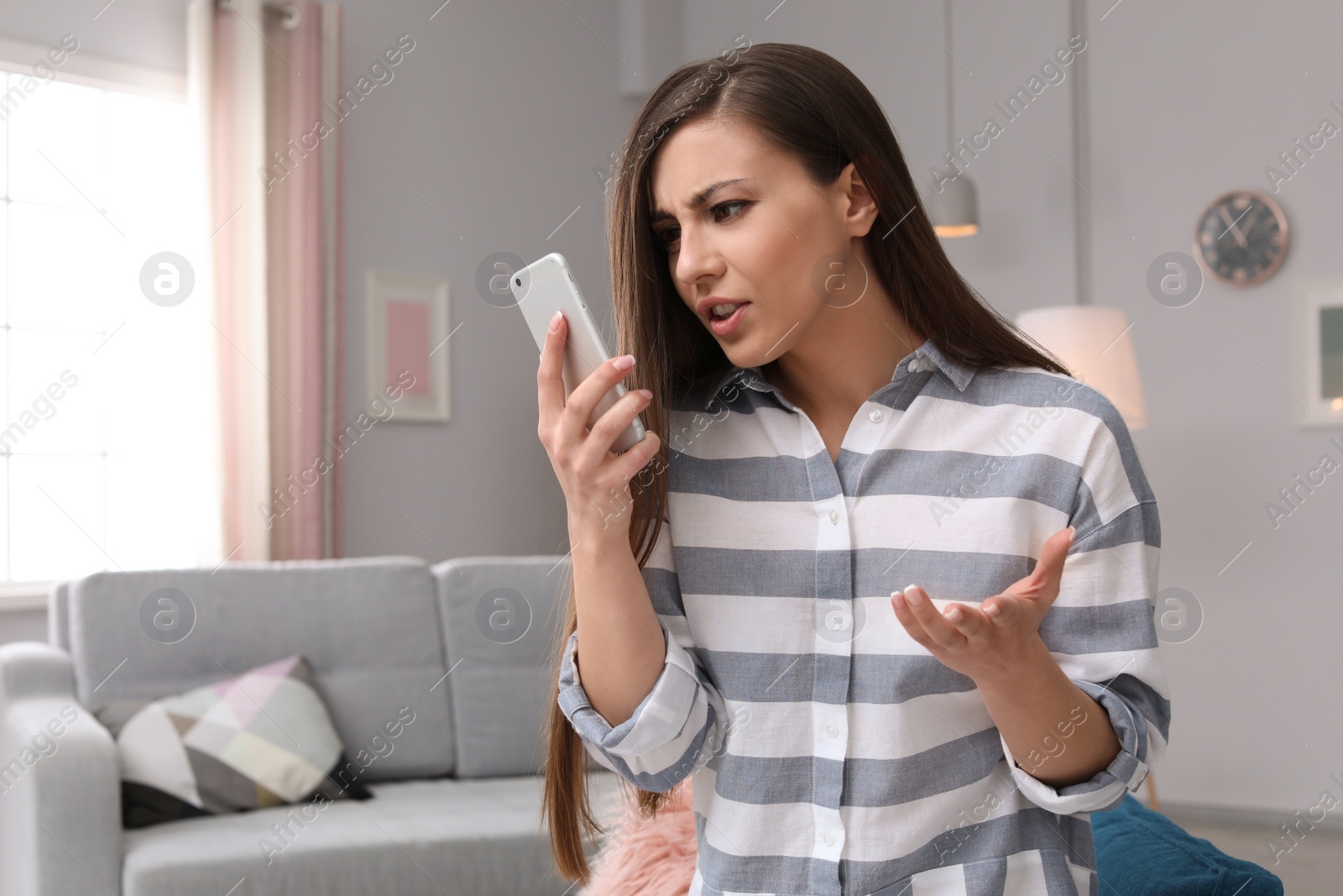 Photo of Woman arguing on mobile phone at home