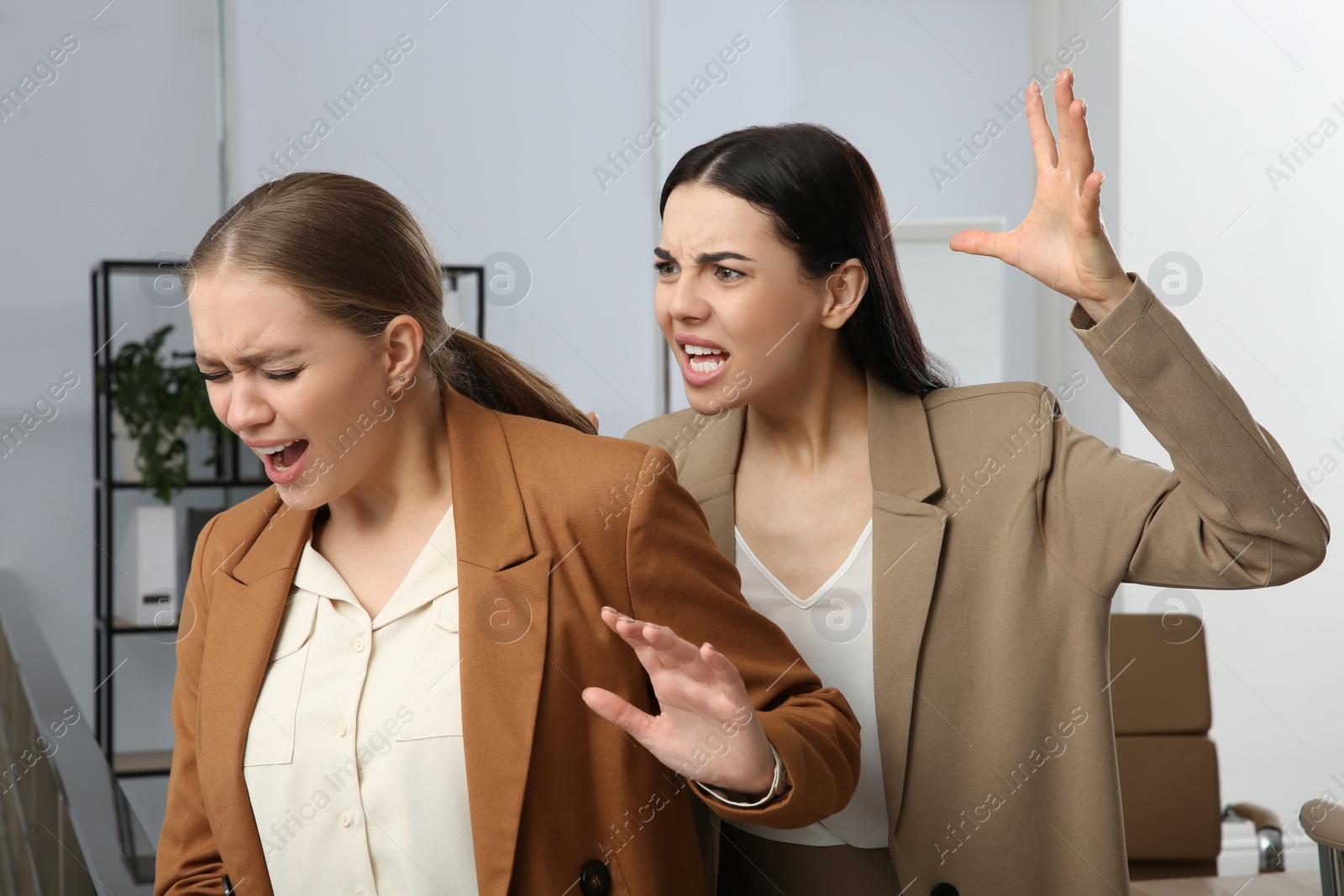 Photo of Emotional colleagues fighting in office. Workplace conflict