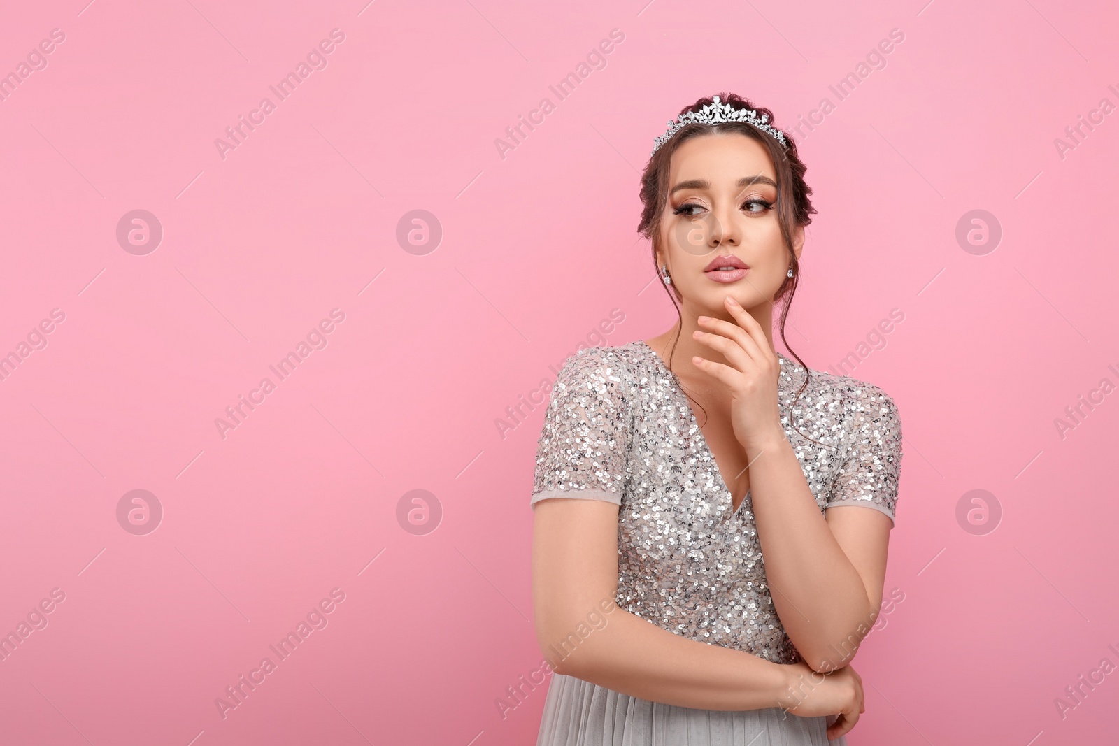 Photo of Beautiful young woman wearing luxurious tiara on pink background, space for text