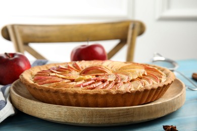 Photo of Delicious homemade apple tart on light blue wooden table