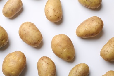 Photo of Fresh raw potatoes on white background, flat lay