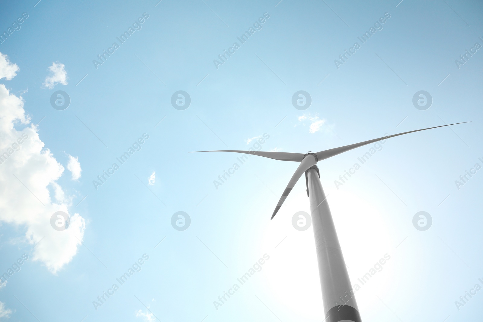 Photo of Modern wind turbine against blue sky, low angle view. Energy efficiency