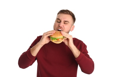 Photo of Young man eating tasty burger on white background