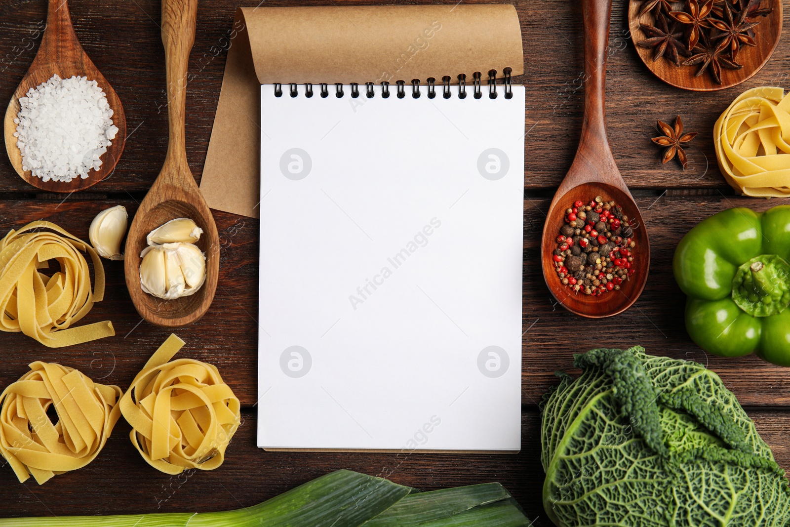 Photo of Notebook and different fresh products on wooden table, flat lay with space for text. Cooking Classes