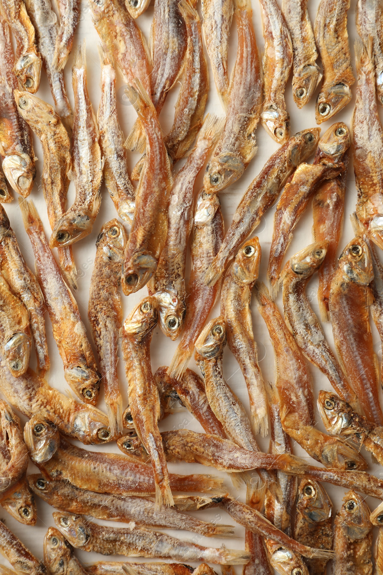 Photo of Many dried anchovies on white table, flat lay