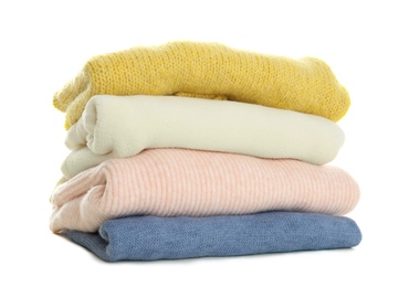 Stack of different warm sweaters isolated on white