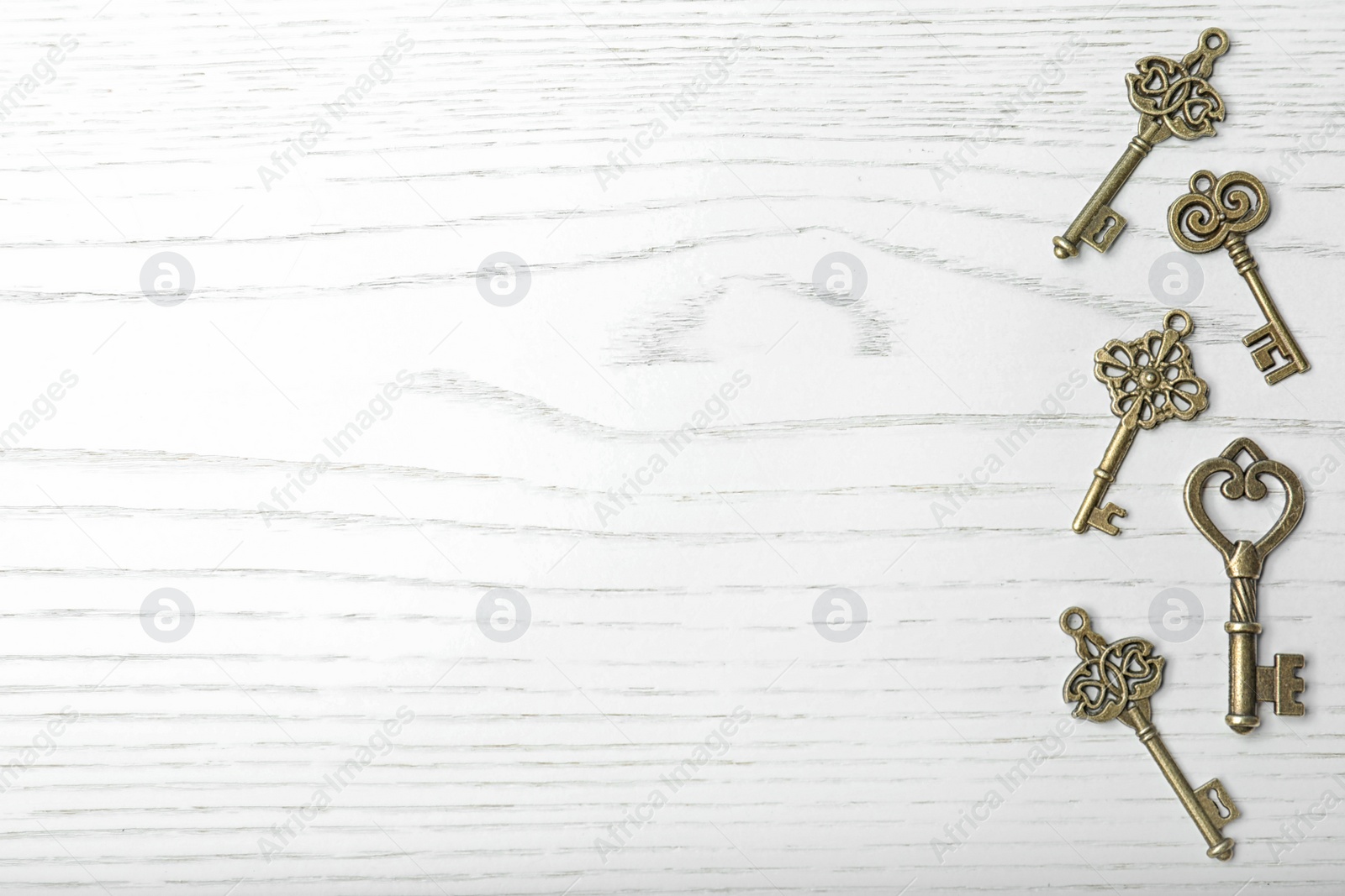 Photo of Old vintage keys on wooden background, flat lay. Space for text
