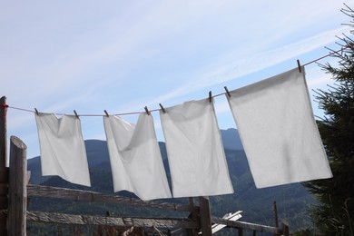 Photo of Laundry with clothes pins on line outdoors