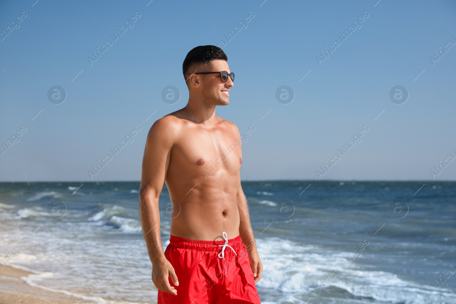 Photo of Handsome man with attractive body on beach