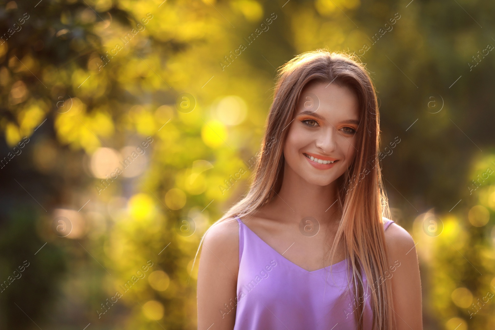 Photo of Beautiful young woman posing outdoors on sunny day