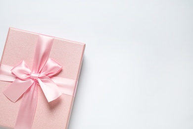 Photo of Pink gift box on white background, top view. Space for text
