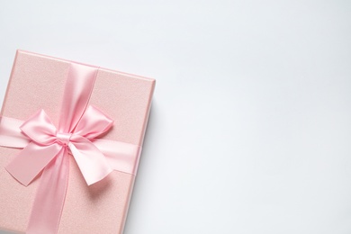 Pink gift box on white background, top view. Space for text