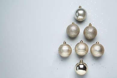 Christmas tree shape made of decorative balls on light background, flat lay. Space for text