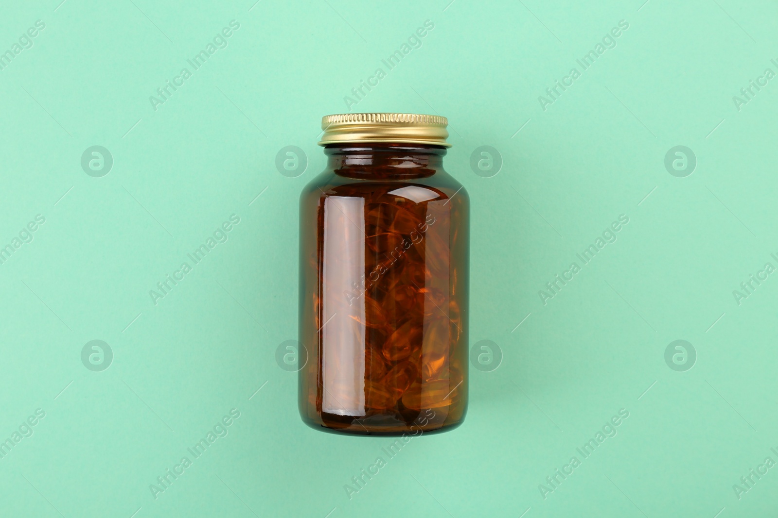 Photo of Bottle with vitamin capsules on turquoise background, top view