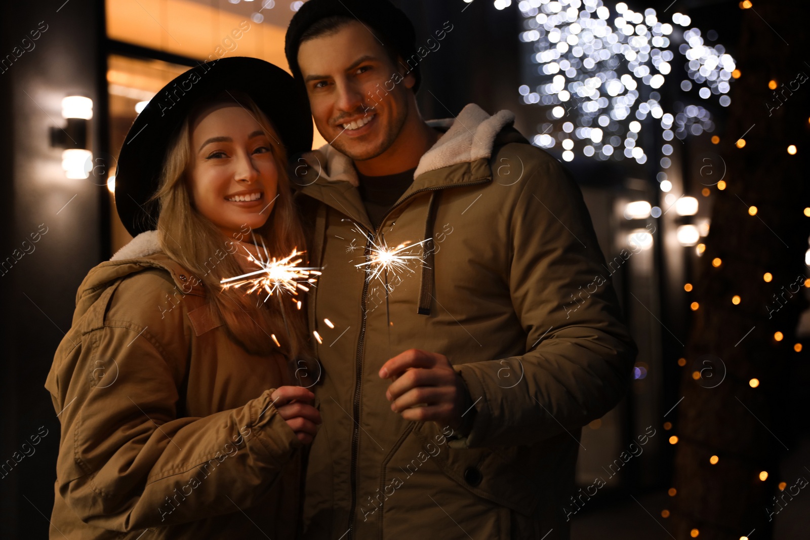 Photo of Happy couple with sparklers at winter fair