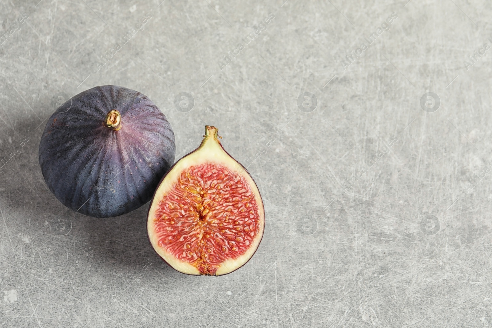 Photo of Fresh ripe figs and space for text on gray background, top view