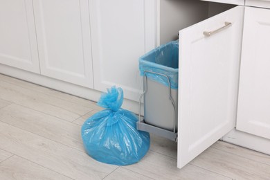 Photo of Plastic garbage bag and trash can indoors