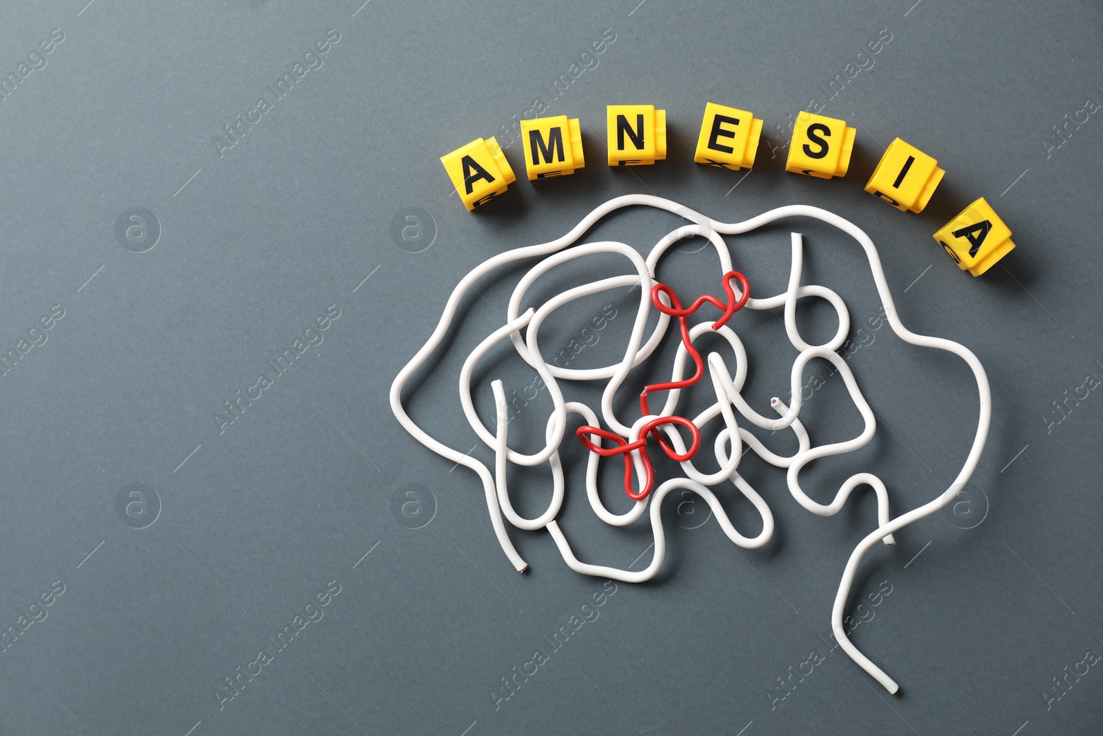 Photo of Word Amnesia and brain made of wires on grey background, flat lay. Space for text