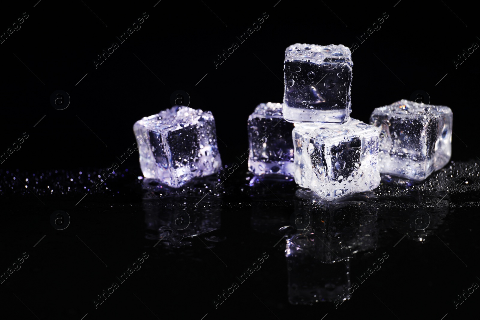 Photo of Pile of crystal clear ice cubes on black background