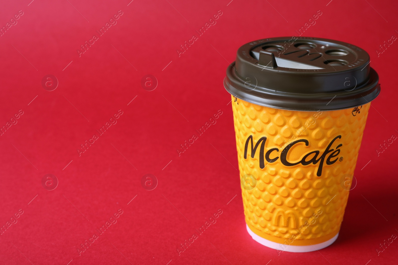 Photo of MYKOLAIV, UKRAINE - AUGUST 12, 2021: Hot McDonald's drink on red background. Space for text