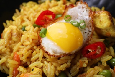 Photo of Tasty rice with meat, egg and vegetables in bowl, closeup