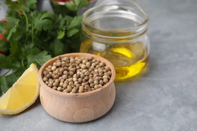 Photo of Aromatic peppercorns and different fresh ingredients for marinade on grey table. Space for text