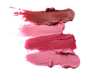 Photo of Smears of bright lipsticks on white background, top view