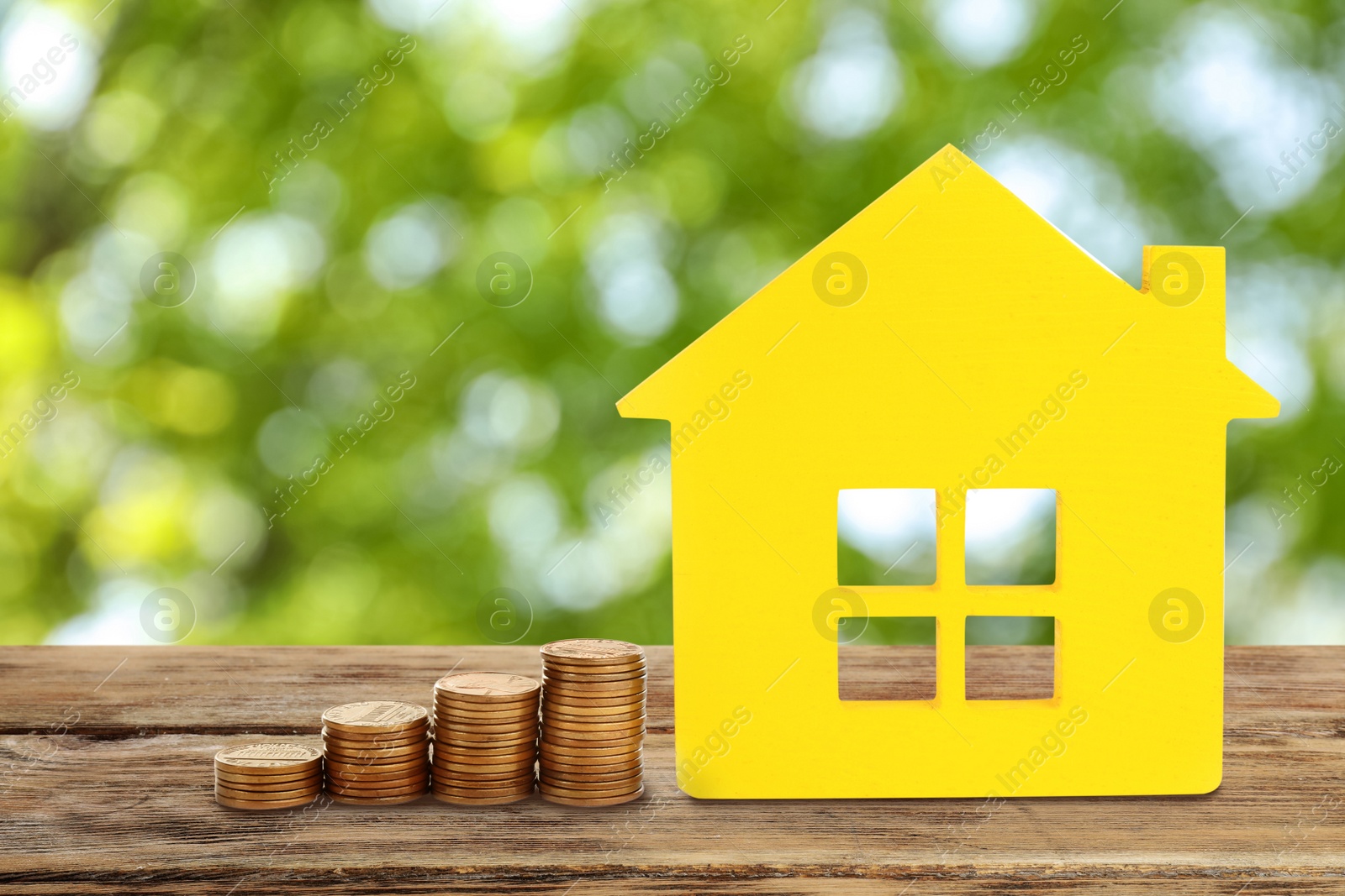 Image of Real estate investing. House model and coins on wooden table