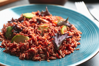 Photo of Tasty brown rice with vegetables on table, closeup