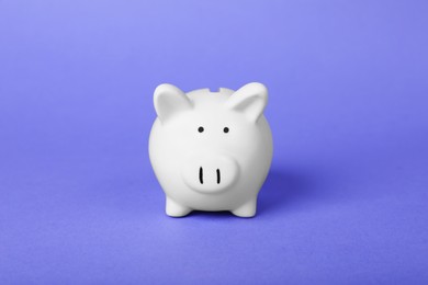 Photo of Ceramic piggy bank on purple background. Financial savings