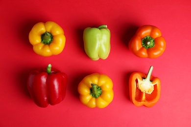 Flat lay composition with ripe bell peppers on red background