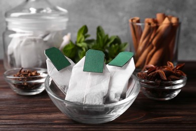 Tea bags and ingredients on wooden table, closeup