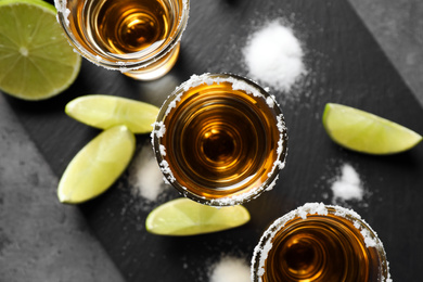 Mexican Tequila shots with salt and lime on grey table, top view