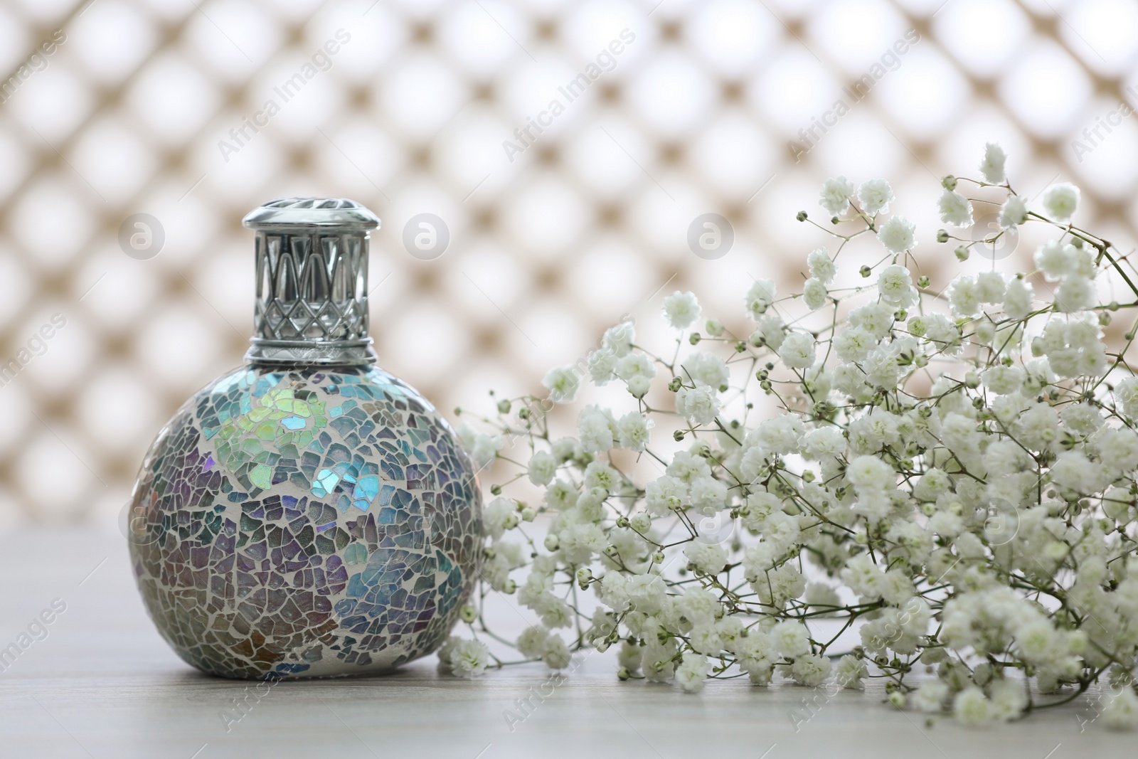 Photo of Beautiful catalytic purifying lamp and flowers on table. Interior element