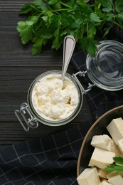 Delicious tofu cream cheese and parsley on black wooden table, flat lay