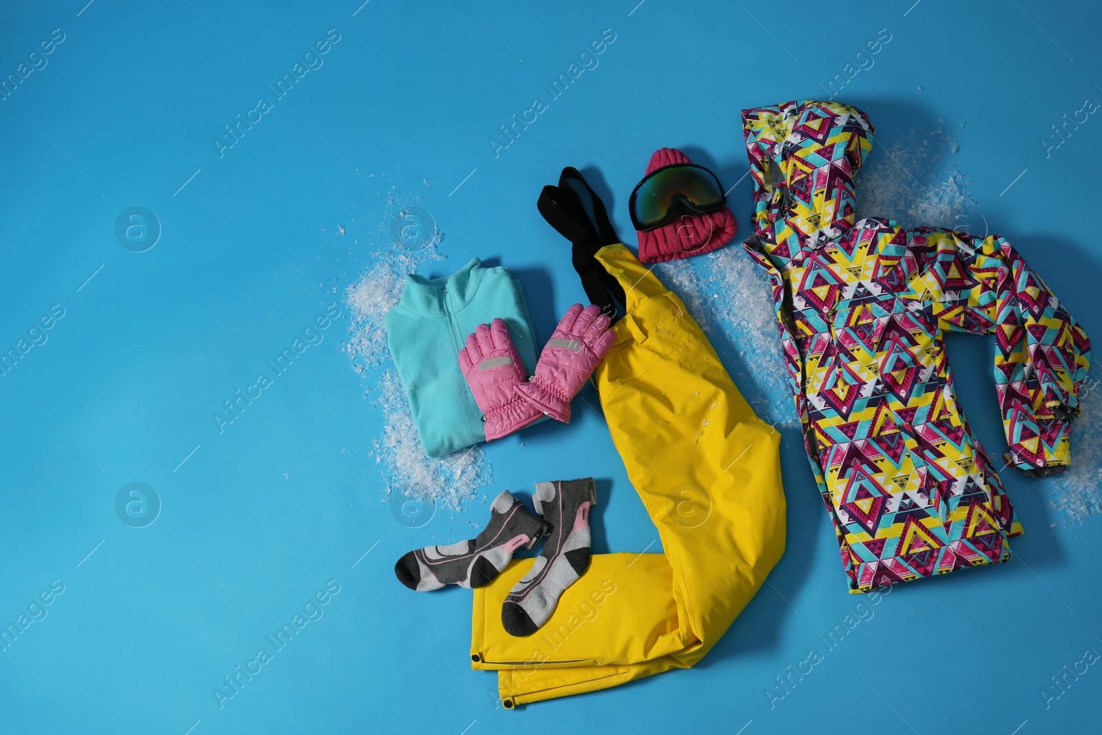 Photo of Stylish winter sport clothes on light blue background, flat lay