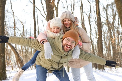 Happy family spending time together in snowy forest