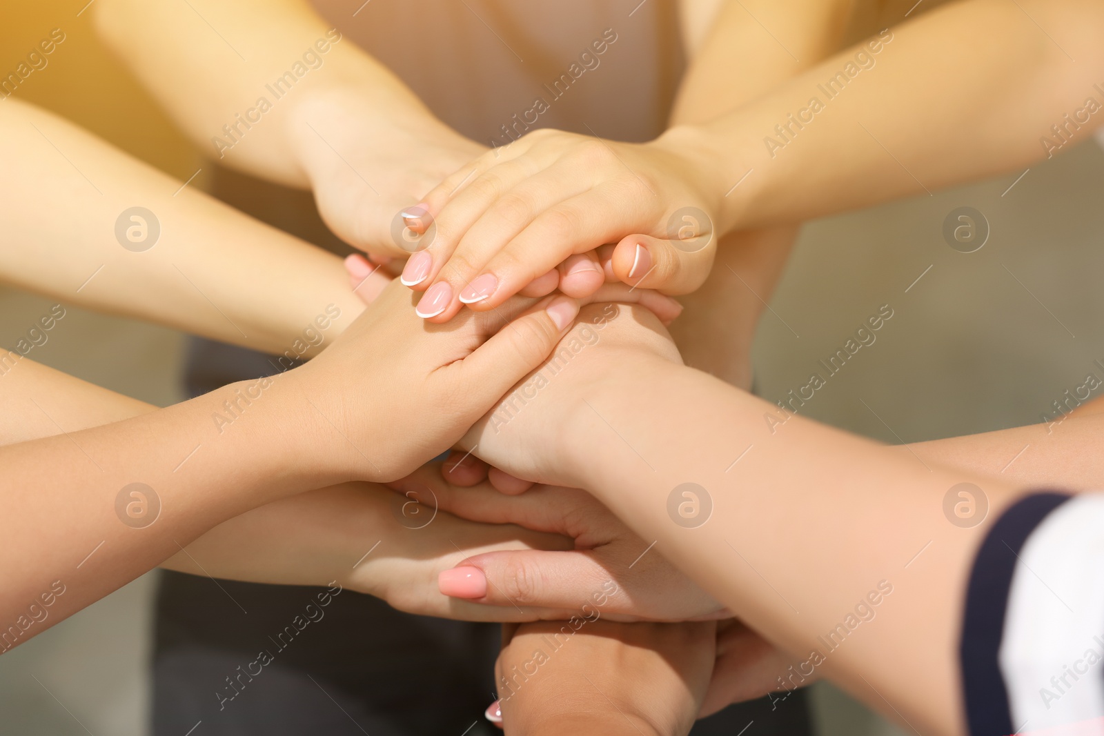 Photo of Group of people holding hands together indoors, closeup. Unity concept