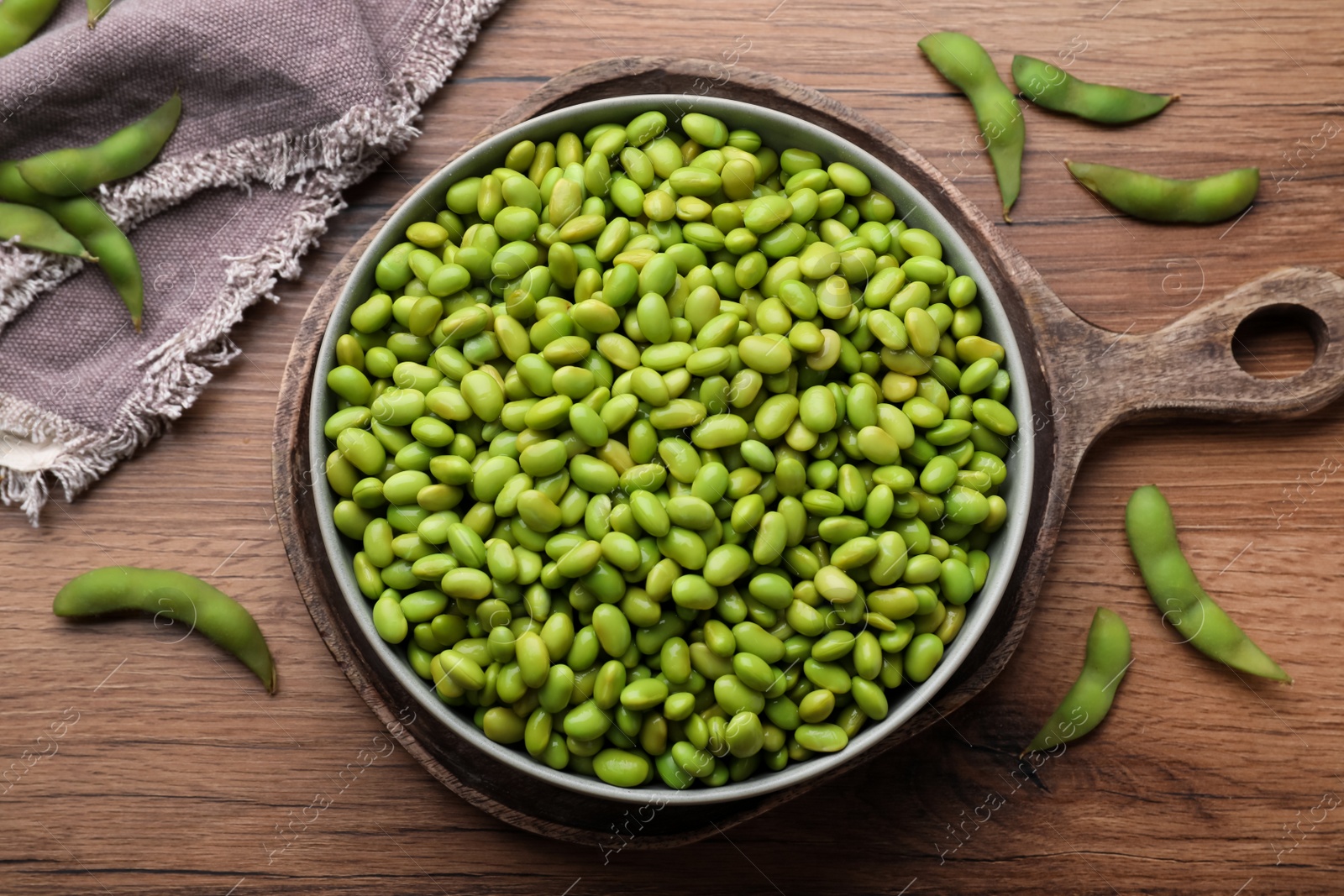 Photo of Organic edamame beans on wooden table, flat lay