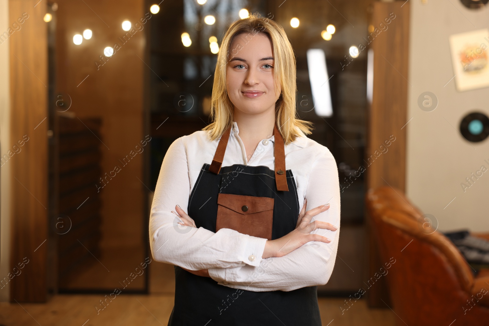 Photo of Portrait of professional hairdresser wearing apron in beauty salon