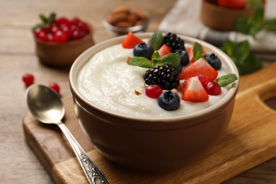 Delicious semolina pudding with berries on wooden table